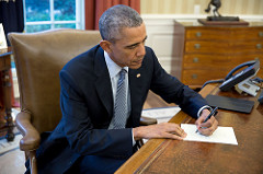 President Barack Obama signs a letter in the Oval Office on March 14. (Pete Souza)