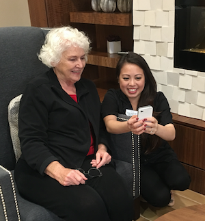 Wellness Director Natalie Nguyen reviews daily tasks with resident Pat Ham and shows her Notify.