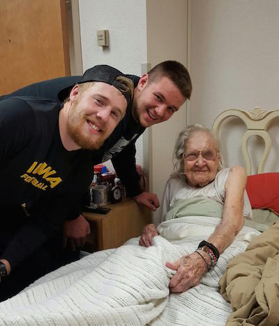 101-year-old Alice Isenhower beams with C. J. Beathard, left, and Ike Boettger of the Hawkeyes.