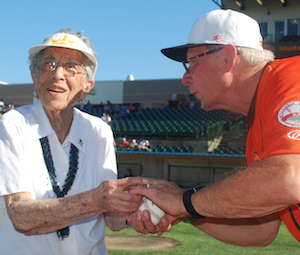 Helen Stemple strategizes with Bud Harrelson before she throws the ceremonial pitch to him.