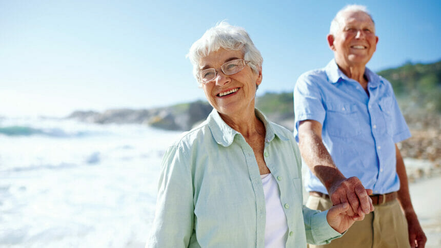 Elderly couple walking on beach