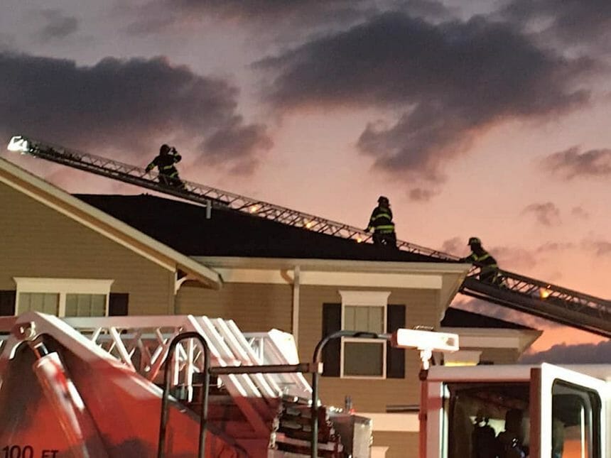 Three firefighters on the roof of Heather Glen Senior Living.