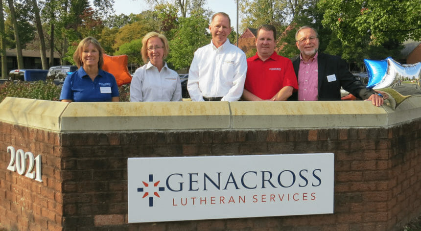 Genacross leadership team poses by sign