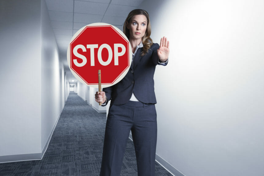 Woman holding stop sign in a hallway