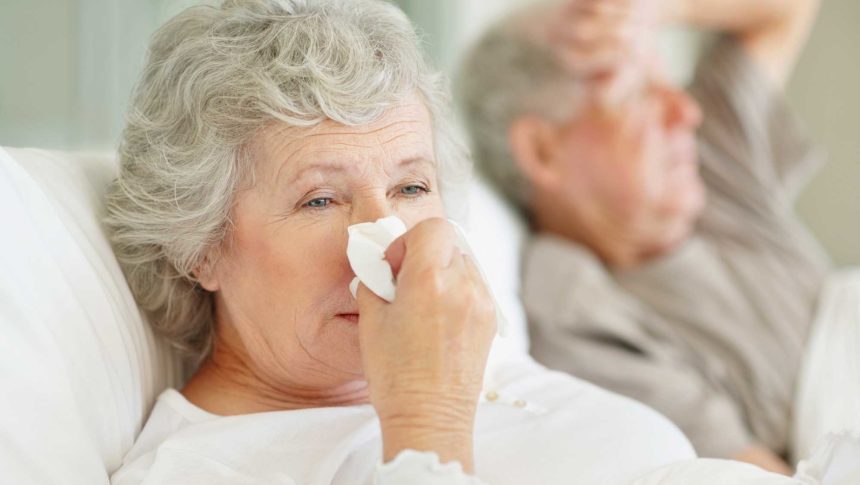 older woman wiping her nose with a tissue