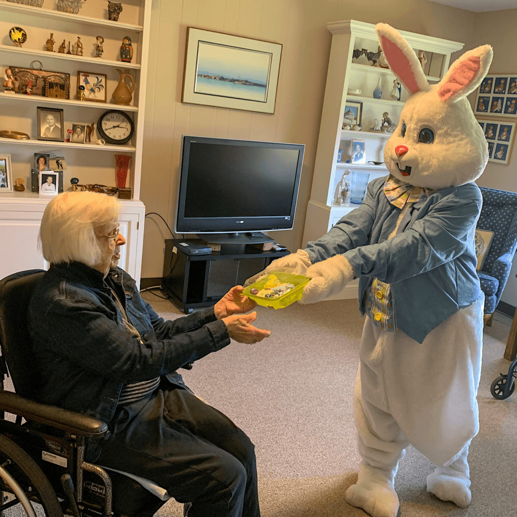 Easter Bunny giving sweets to an older woman.