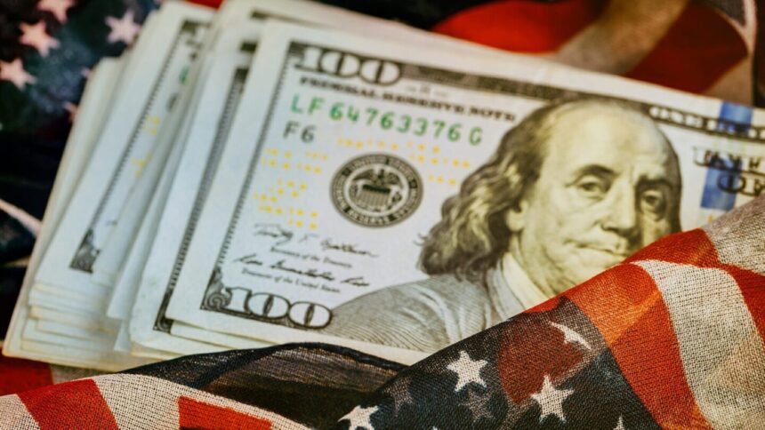 $100 bills on top of American flag