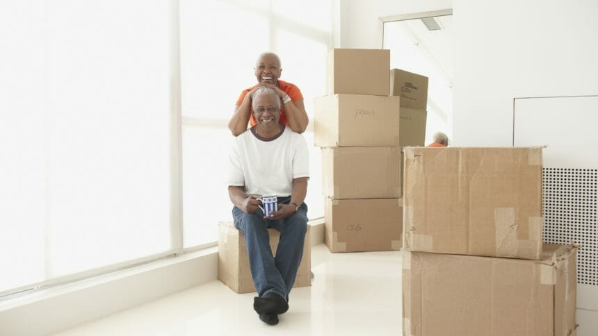 older Black couple sitting near moving boxes