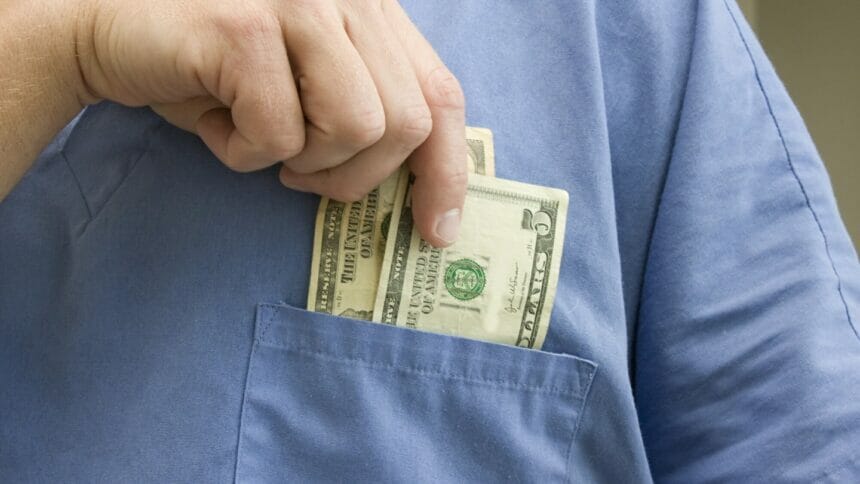man putting money into his shirt pocket