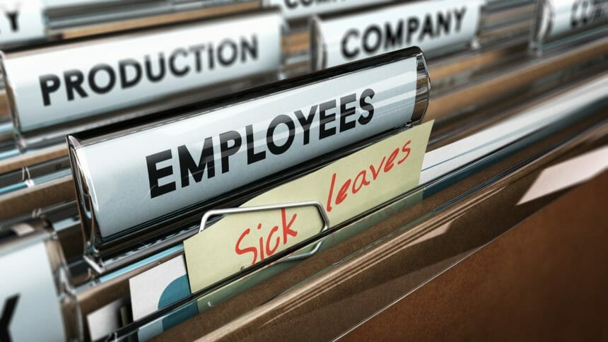 Close up on a file tab with the word employees plus a note with the text sick leaves, blur effect at the background. Concept image for illustration of sick leave