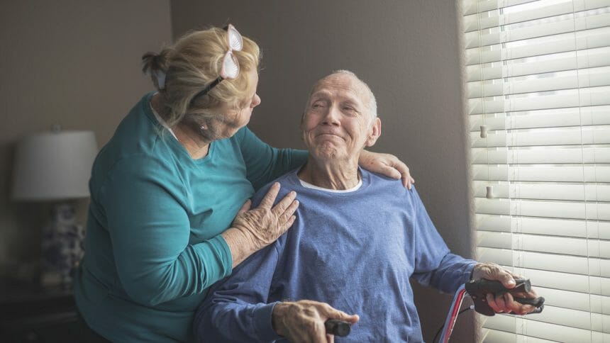 Family caregiver with disabled elderly man