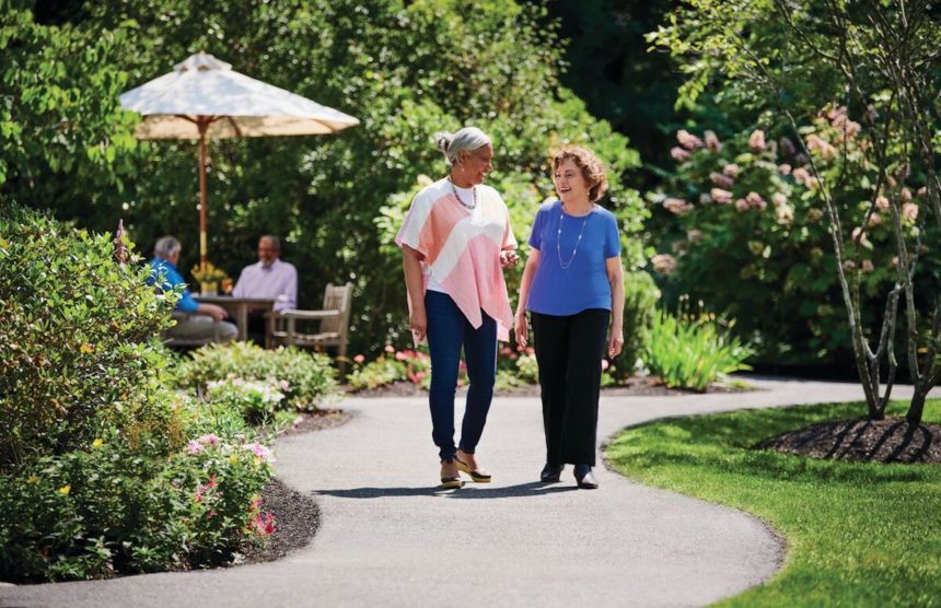 two older adults walk on a path