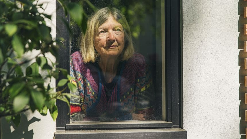 older adult looking out a window