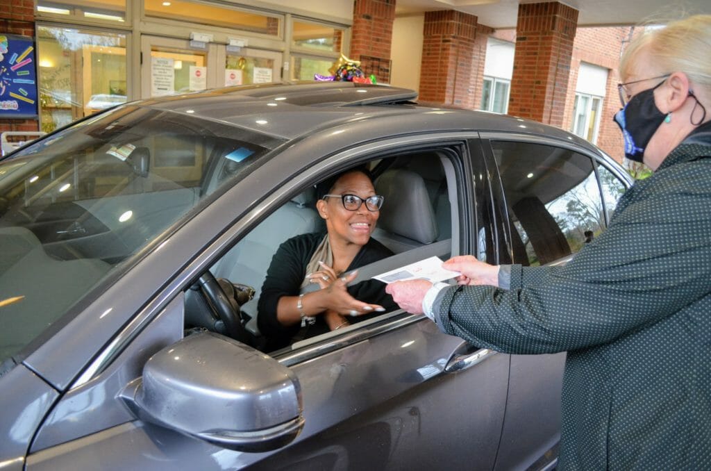 Woman in car receiving check