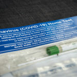 At-home COVID-19 test instructions and package with nasal swab