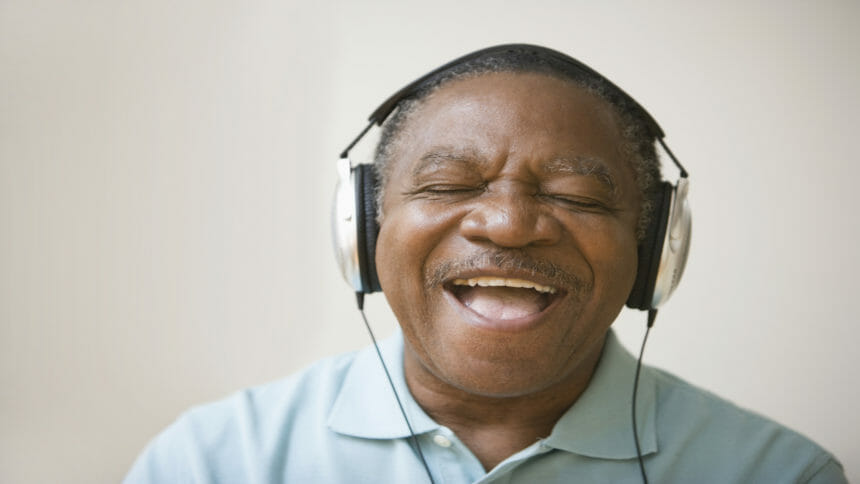 Smiling senior enjoys sounds from headphones