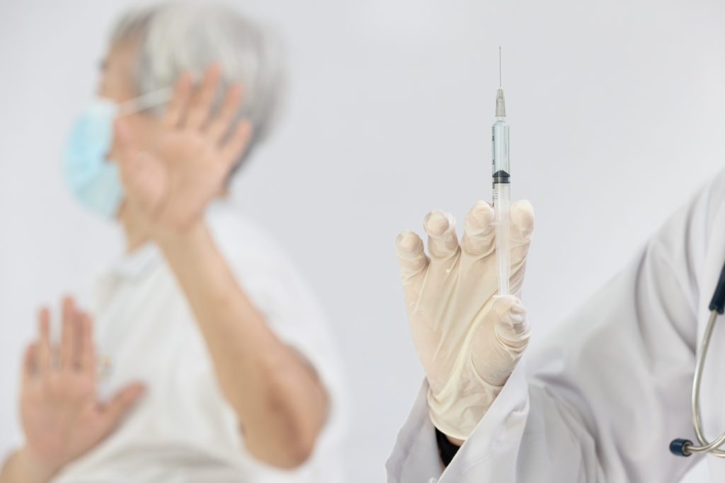 woman holding hand up against vaccination