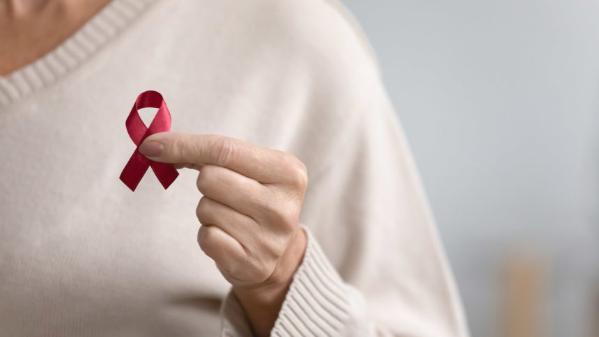 woman holding red AIDS ribbon