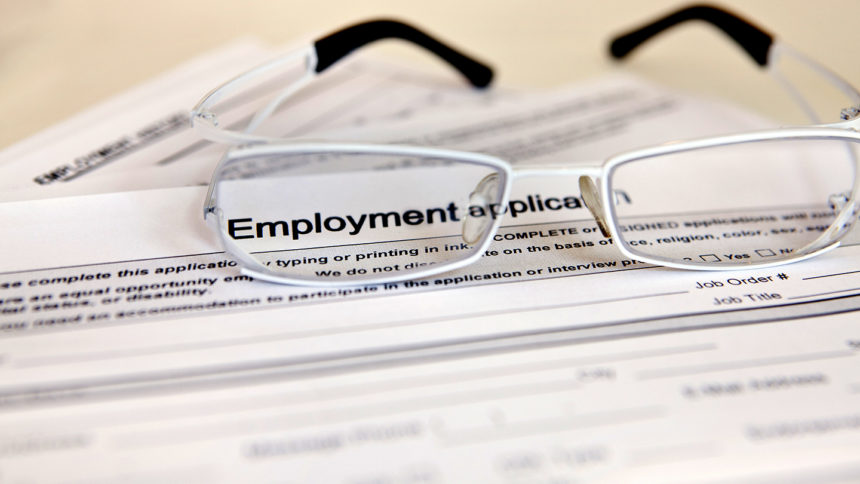 Closeup of a pair of glasses sitting on an employment application