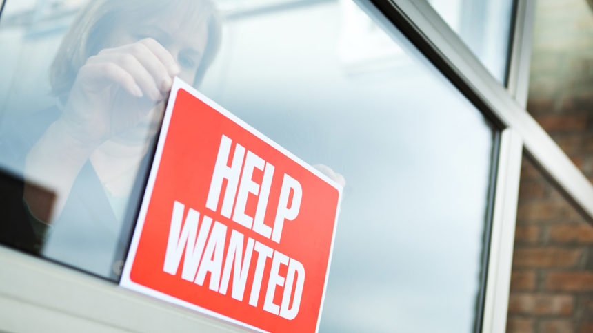 woman posts help wanted sign