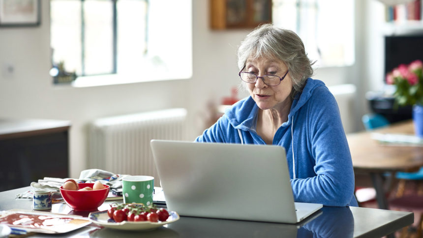 woman sitting at table working on laptop