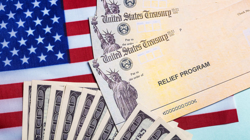 Large bills and Treasury relief program checks layered on American flag