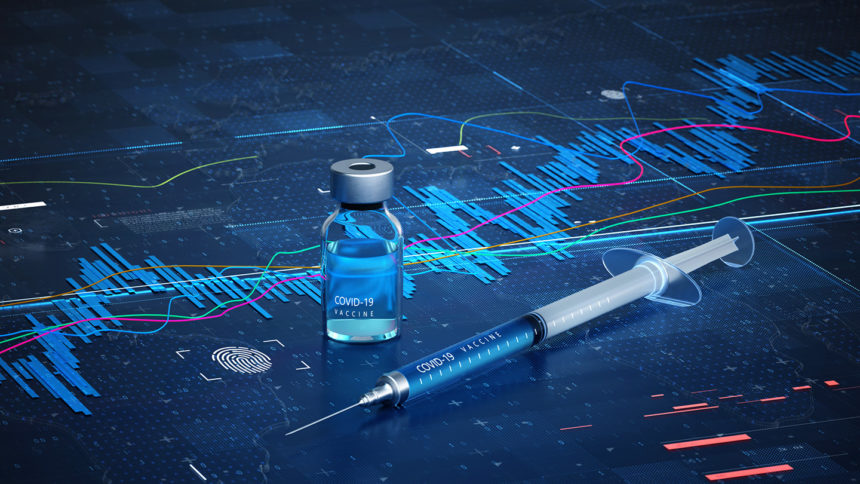 COVID-19 syringe and vaccine bottle on data surface.
