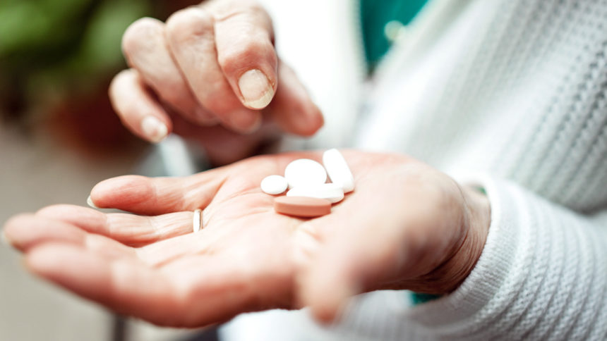 closeup of woman holding pills in open palm