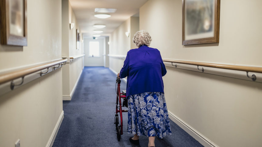 woman walking down hallway with walker