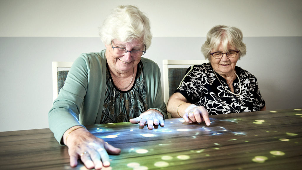 Two older adults using a Magic Table