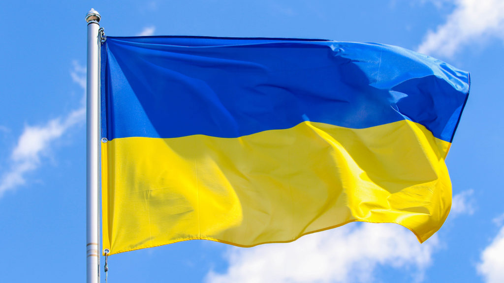 Flag of Ukraine against blue sky background