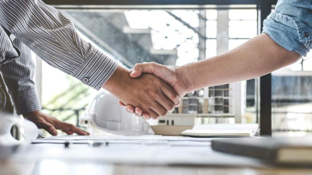handshake over table at construction project