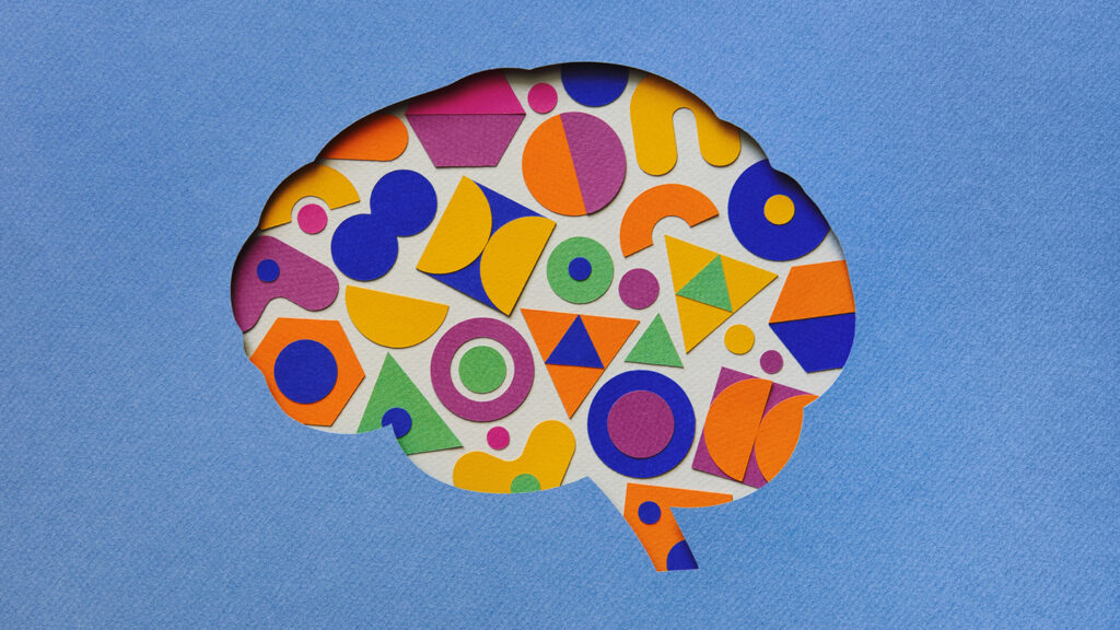 Paper craft illustration of the brain filled with multi-colored geometric shapes.  Creative mind