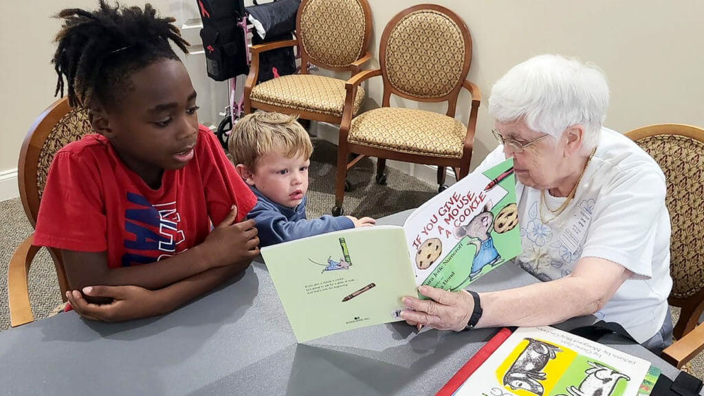 Older woman reading to two children
