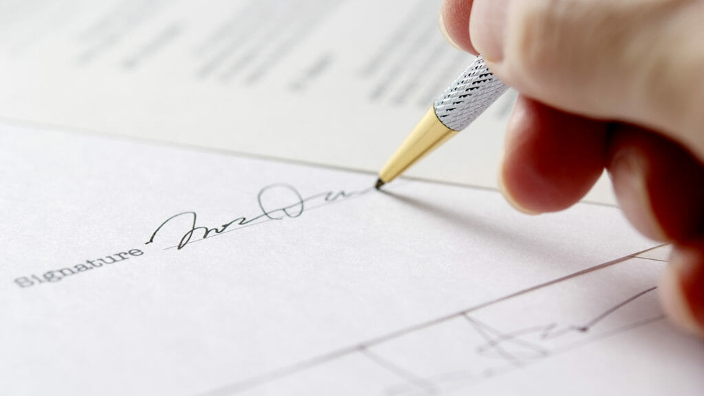 Close-up of signing a contract with shallow depth of field.