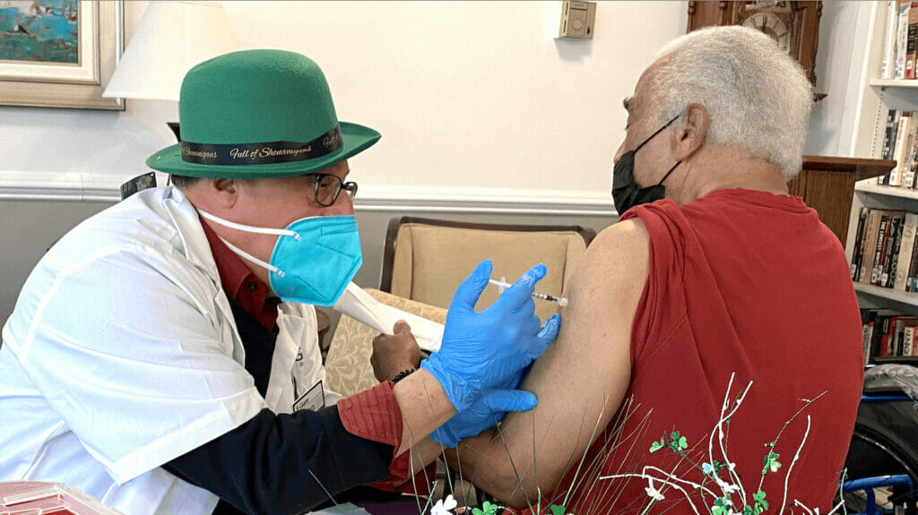 man giving a senior living resident a vaccine