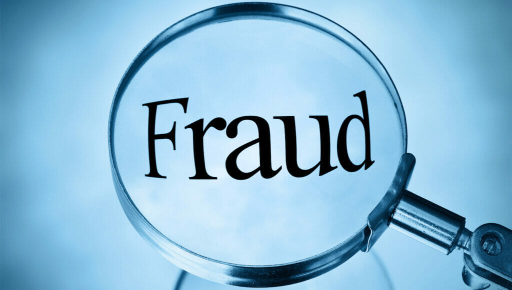 magnifying glass examining the word fraud