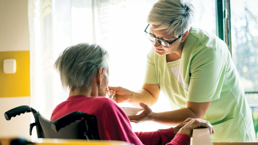 Caregiver feeding an older adult