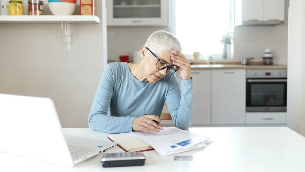Serious Senior Woman Analyzing Home Finances With Laptop