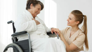 older woman sitting in wheelchair in bathrobe