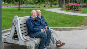 two men sitting on a park bench