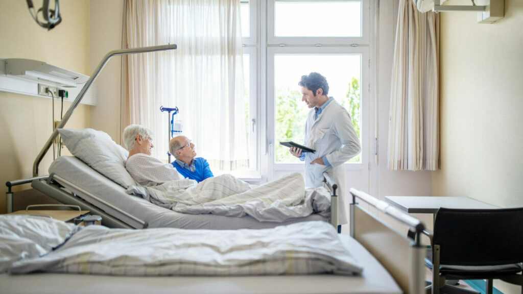 bedridden patient, family member and doctor in hospital room