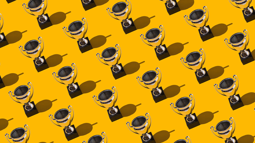 Trophy cups winner champion cups pattern with hard shadow on yellow background. Concept of victory, winner, european champion, world champion, soccer and sport.