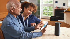 caregiver and man looking at smartphone