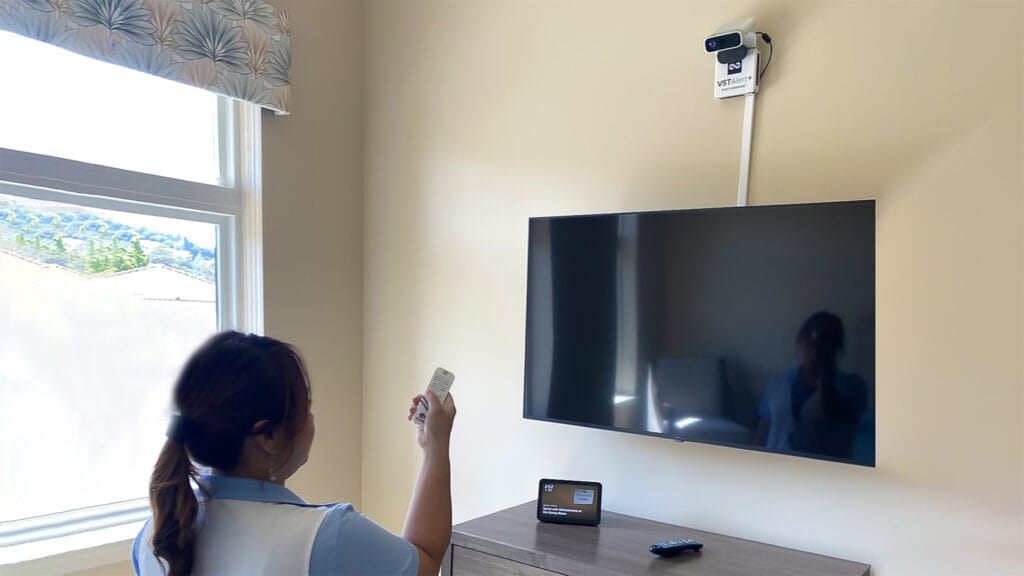 woman holding remote in front of TV set