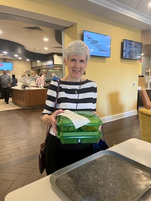 REsident picking up reusable carryout containers.