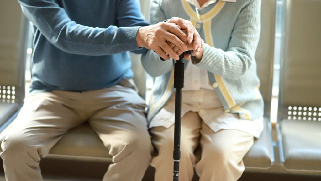 Senior couple holding hands with walking cane