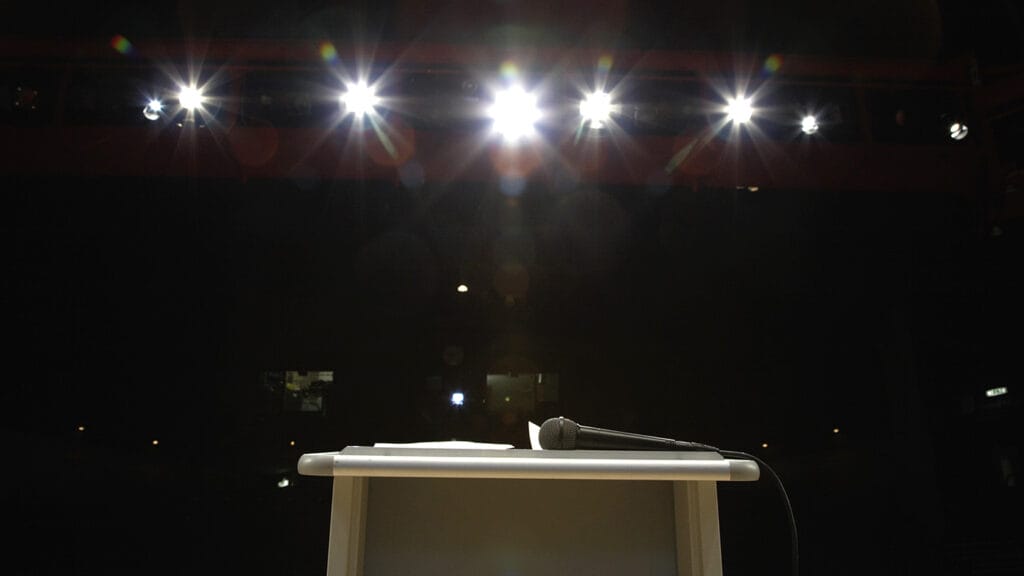 Microphone on lectern in illuminated auditorium