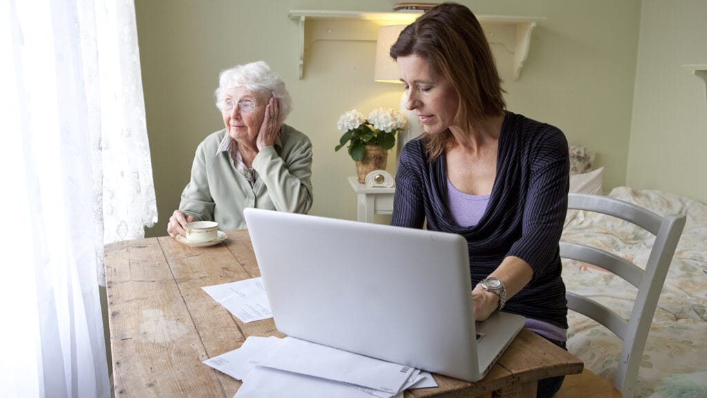Woman paying bills for elderly mother