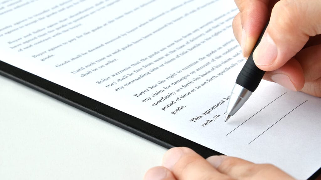 Human's hands signing contract in English